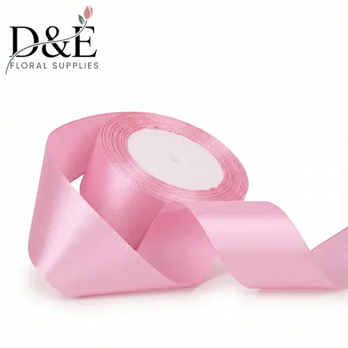 Pink 1.5 inch single face satin ribbon roll on white background