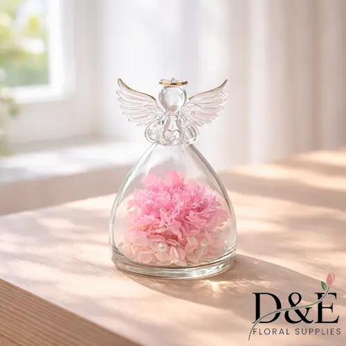 Pink preserved carnation displayed inside an angel glass bottle